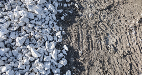Top view, pile of white and gray stone on the soil ground with natural sunlight. Abstract two tone...