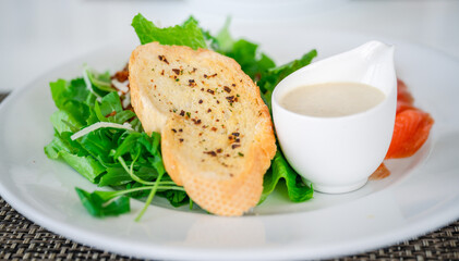 Salad with Crispy garlic bread-Italian and salad dressing, side view, selective focus.
