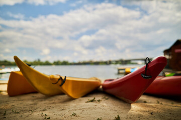 colorful kayaks. Colorful fiberglass kayaks on a sandy beach. Colorful kayaks on the beach. Colorful boats, kayaks on the beach.