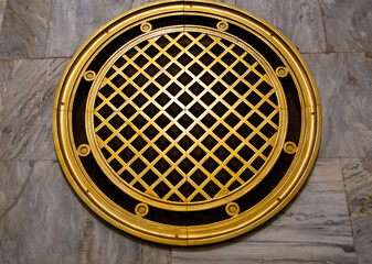 The ventilation grille is bronze with several circles and squares in the center. Architecture technology construction.