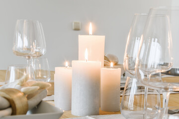 Burning candles and wineglasses on table