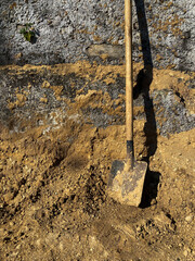 A shovel used for digging sand in construction work. Shovel on the background of the wall. Side view. copy space.