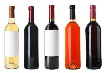 Set with bottles of different delicious expensive wines on white background