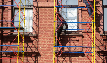 Metal scaffolding at the brick wall of the building.