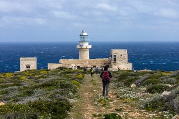 hikers walk towards the Capo Grosso lighthouse on the island of Levanzo. (Egadi) Aegadian Islands,...