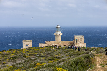 Fototapeta na wymiar hikers walk towards the Capo Grosso lighthouse on the island of Levanzo. (Egadi) Aegadian Islands, Trapani, Sicily, Italy