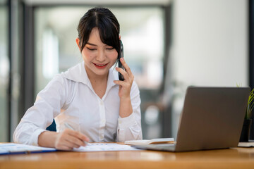 business woman using, touching on mobile smart phone screen while working on laptop computer on desk at home office, E-business, internet technology concept