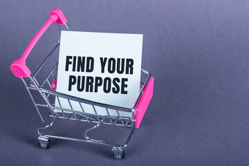 Top view of Find your purpose phrase on a white card inside a shopping cart on dark gray background.