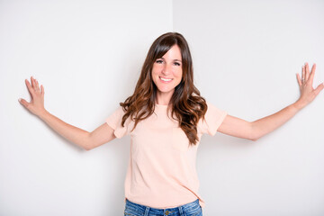 Happy carefree woman with joyful expression, smiling while standing in relaxed pose against white background