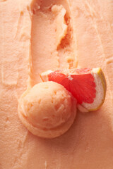 Grapefruit sorbet texture and ball with a slice of fresh grapefruit.