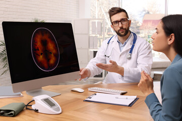 Neurologist showing brain scan to young woman in clinic