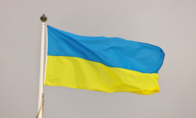 Ukraine national flag waving in wind against cloudy sky. Ukrainian Flag on flagpole flapping