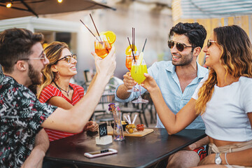 Millennial people on vacation meet at outdoors pub in the summer - Group of young friends toasting...