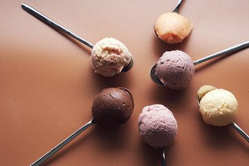 Composition of organic ice cream of different flavors in silver spoons.
