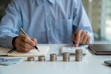 business man counting coins and banknotes by taking notes profit from doing business For saving money, saving money for the future and life after retirement