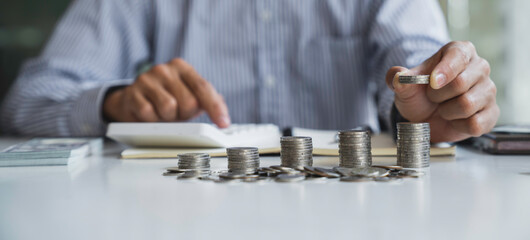 business man counting coins and banknotes by taking notes profit from doing business For saving...