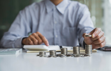business man counting coins and banknotes by taking notes profit from doing business For saving...