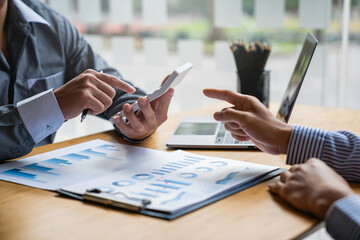 Business professionals working together at office desk, hands close up pointing out financial data on a report, teamwork concept