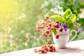 Summer bouquet of wild strawberries and wildflowers on the windowsill