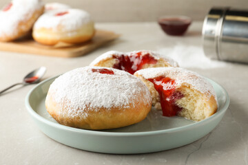 Naklejka na ściany i meble Delicious donuts with jelly and powdered sugar on light grey table, closeup
