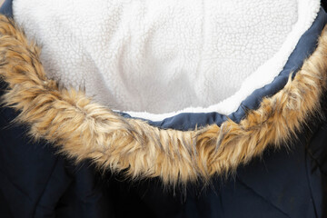 Hood with faux fur on a blue winter jacket close-up