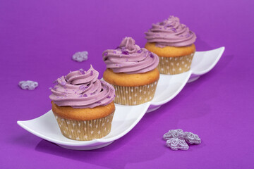 Cupcakes with violet scented swiss meringue buttercream decorated with pieces of violet candy