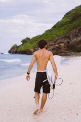 Surfboard Surfer Outdoor Sport Tropical Ocean Concept. Young handsome man with a surfboard on the ocean.