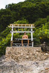 Surfboard Surfer Outdoor Sport Tropical Ocean Concept. Young handsome man with a surfboard on the ocean.