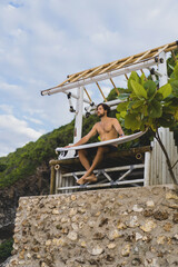 Surfboard Surfer Outdoor Sport Tropical Ocean Concept. Young handsome man with a surfboard on the ocean.