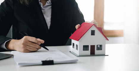 Female woman hands holding home model, small miniature white toy house. Mortgage property insurance dream moving home and real estate concept