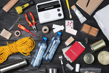 Disaster supply kit for earthquake on black wooden table, flat lay