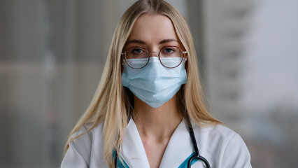 Female doctor in medical mask looking at camera talking angry show index finger no negative gesture...