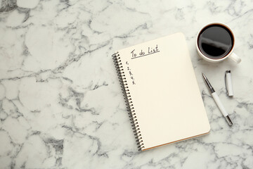 Notepad with unfilled To Do list, pen and cup of coffee on white marble table, flat lay. Space for text