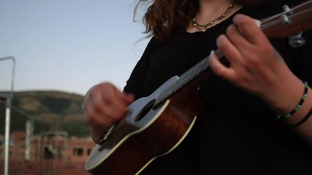 Plano cerrado de mujer tocando un ukulele. Concepto musical