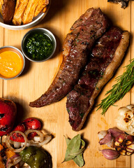 fotografía de carne asada, vegetales y chimichurri. 