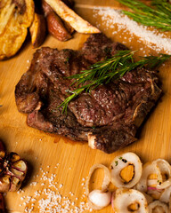 fotografía de carne asada, vegetales y chimichurri. 