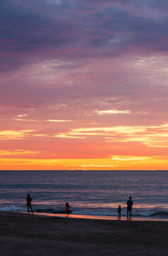 Beach of Same at sunset with people silhouettes and Pacific Ocean sea, Esmeraldas province, Ecuador.