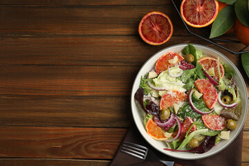 Delicious sicilian orange salad served on wooden table, flat lay. Space for text
