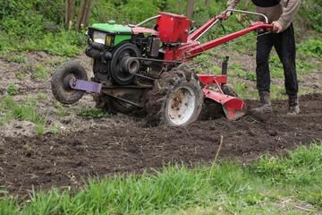 Man farmer working in field ploughing land with plough on farm. Season processing soil in village. Organic cultivate natural products. Agriculture