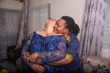 African lgbt couple at home cuddle and hug each other, partrners in love indoors, trans person with his girlfriend. - obrazy, fototapety, plakaty