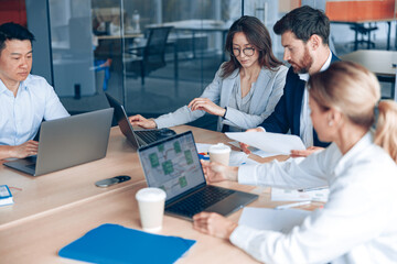 Focused business people are using gadgets and talking during the conference in office Teamwork...