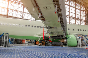 Maintenance and repair of a passenger aircraft wing. Wing flaps disassembled released.