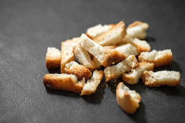Crackers, dried baked bread white, bunch of broken on dark background, selective focus.