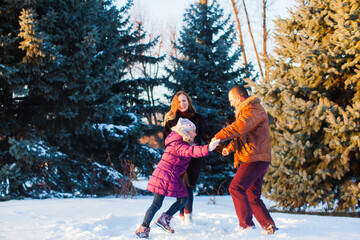 The happy family having fun outdoors in winter