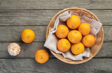 Tangerines with cut fruit over wooden table