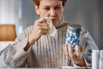 Portrait shot of mature Caucasian woman sitting at desk in front of laptop having online...