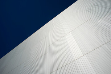 steel cladding on the side of a modern building with a blue sky.