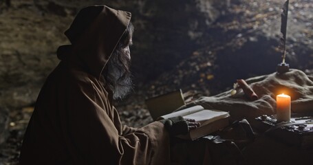 Senior wise man writing with quill