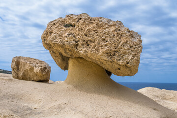 A mushroom shaped rock or rock pedestal, formed by erosion of soft and hard rock in Gozo, Malta