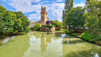 Galileo Galilei Astronomical Observatory, La Specola Tower in Padova, Veneto, Italy, Europe. An Italian medieval tower used as an astronomical observatory, reflection in water. City of Padua